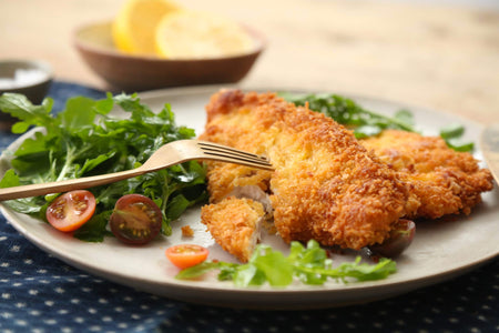 Chicken schnitzel on a plate with a side salad.