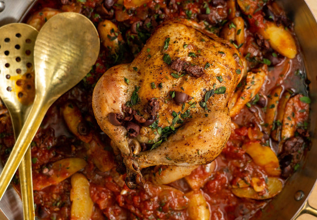Chicken Provencal in a large skillet with serving spoons.