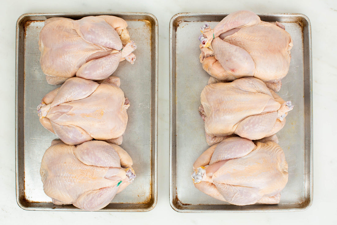 6 whole chickens placed on 2 sheet pans.